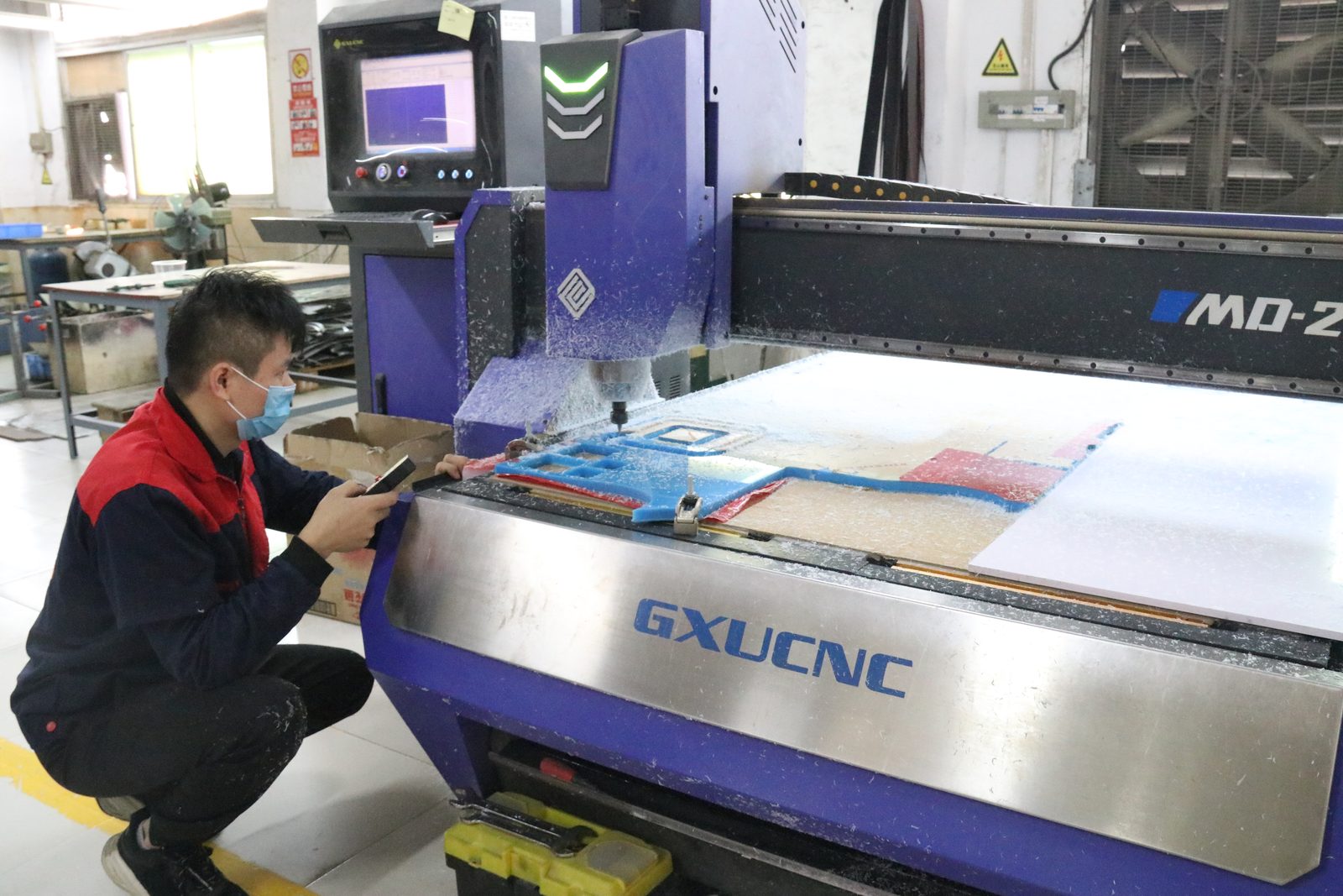 CNC machine engraving a blue acrylic sheet