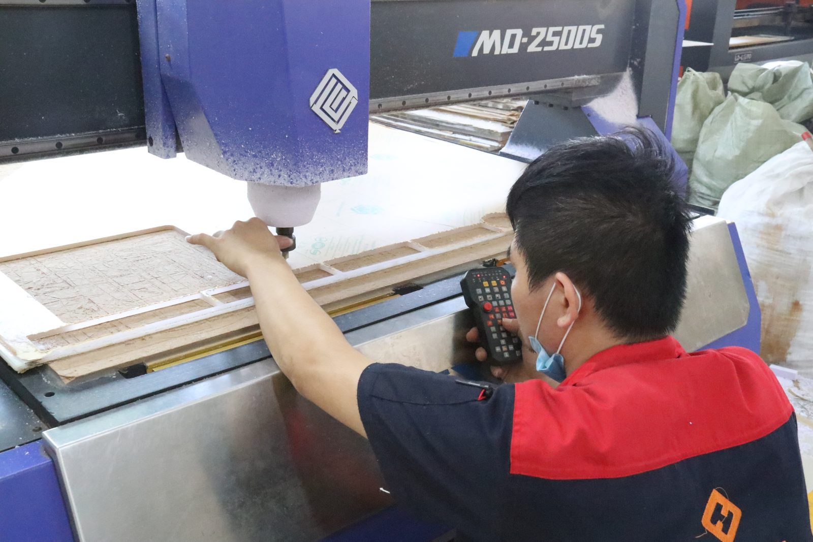 Operator loading acrylic sheets onto a CNC router