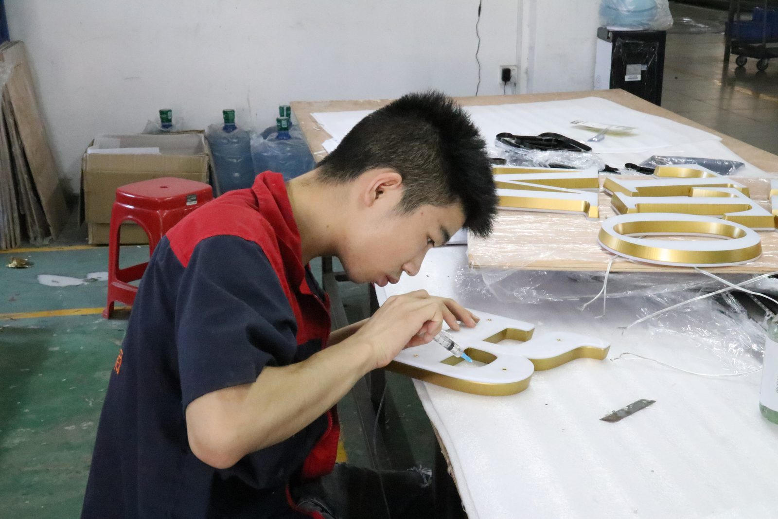 Worker grinding a stainless steel letter in the HeFeng signs factory
