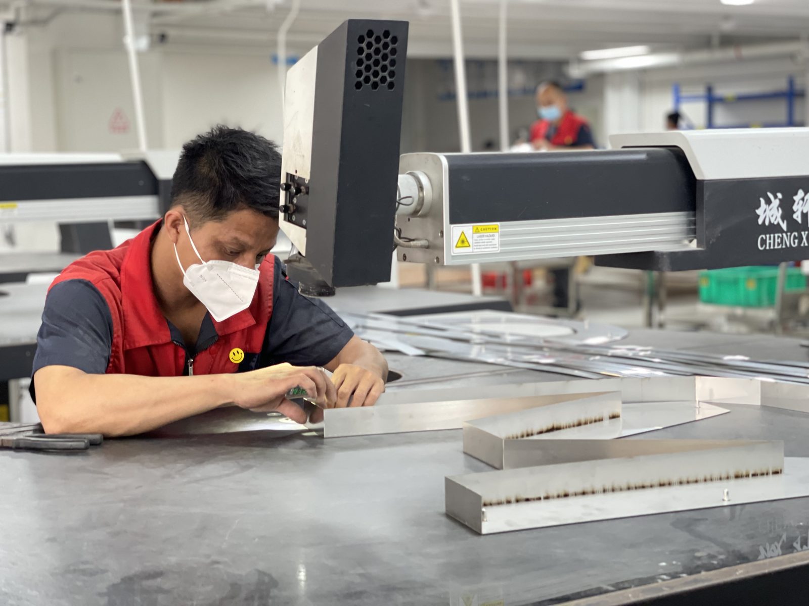 Technician checking parts on the CNC laser cutting table