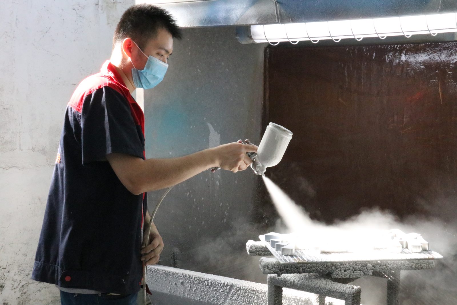 Spray painting booth finishing a sign at the HeFeng factory